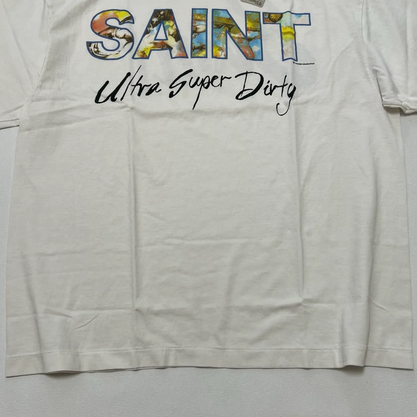 SAINT Mxxxxxx SS TEE/SUPER DIRTY/WHT oil painting SAINT SUPER DIRTY slogan TEE off-white S-XL Made of original OE yarn tube weaving without side seams to distinguish the split fabrics original consistent VINTAGE label/little angel anti-counterfeiting label top printing technology highly restored original details